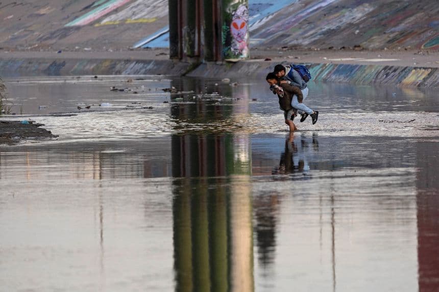 Un traficante transporta a un migrante a través del Río Grande cerca de una zona fronteriza de alto tráfico en El Paso, Texas, el 20 de diciembre de 2022, visto desde Ciudad Juárez, México. (John Moore/Getty Images)