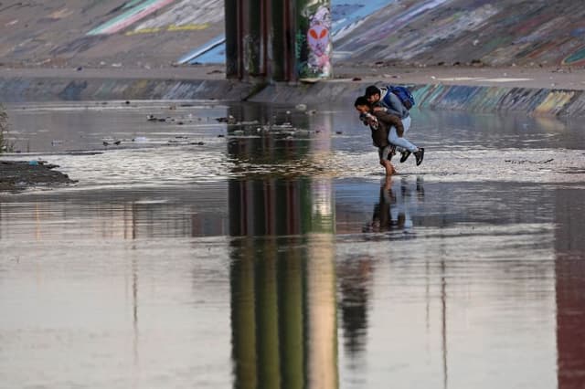 Un traficante transporta a un migrante a través del Río Grande cerca de una zona fronteriza de alto tráfico en El Paso, Texas, el 20 de diciembre de 2022, visto desde Ciudad Juárez, México. (John Moore/Getty Images)