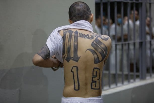 Un recluso muestra los tatuajes que tiene en la espalda en el CECOT (centro de confinamiento antiterrorista) de Tecoluca, el 6 de febrero de 2024, en San Vicente, El Salvador. (Alex Peña/Getty Images)