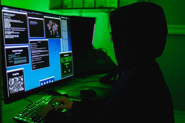 En esta ilustración fotográfica, un hacker escribe en el teclado de una computadora el 13 de mayo de 2025. (Oleksii Pydsosonnii/The Epoch Times).