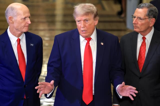 El presidente Donald Trump (C) habla con los medios de comunicación mientras se retira junto al senador estadounidense Rick Scott (R-Fla.) (I) y el líder de la mayoría del Senado de EE. UU., John Barrasso (R-Wyo.), tras reunirse con senadores republicanos en el Capitolio de EE. UU. en Washington el 24 de junio de 2026. (Anna Moneymaker/Getty Images)