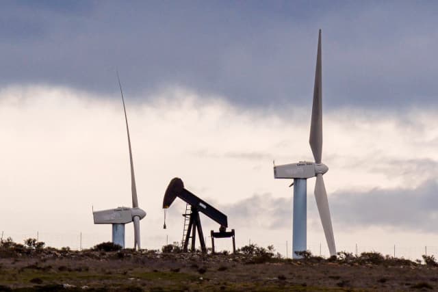 Una bomba de petróleo en un yacimiento en desuso con aerogeneradores al fondo en Sargentes de la Lora, cerca de Burgos, en el norte de España, el 13 de marzo de 2026. (César Manso/AFP vía Getty Images)