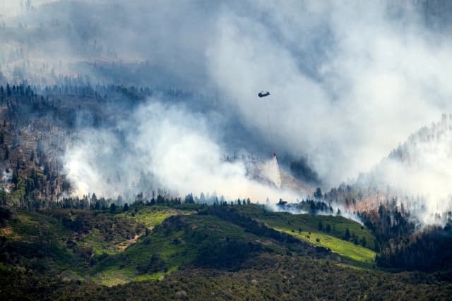 Un helicóptero arroja agua sobre el incendio Cottonwood, que arde cerca de Beaver, Utah, el sábado 27 de junio de 2026. (Foto AP/Noah Berger)