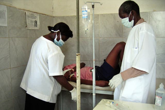 Trabajadores sanitarios angoleños atienden a una mujer de 22 años con sospecha de fiebre hemorrágica de Marburgo en una clínica de Cacuaco, cerca de Luanda, el 5 de abril de 2005. (Florence Panoussian/AFP vía Getty Images).