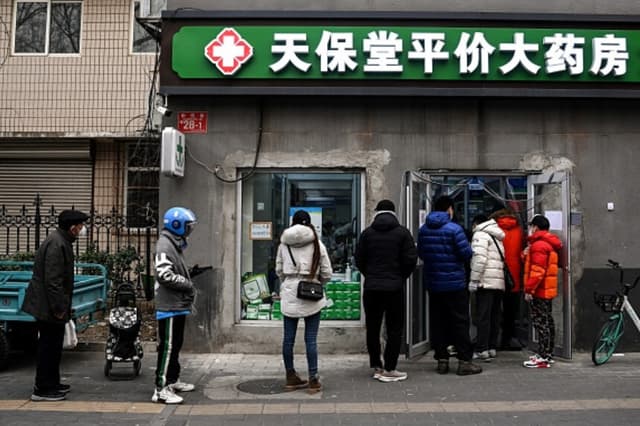 Personas hacen cola para comprar medicamentos en una farmacia de Pekín el 9 de diciembre de 2022. (NOEL CELIS/AFP vía Getty Images).
