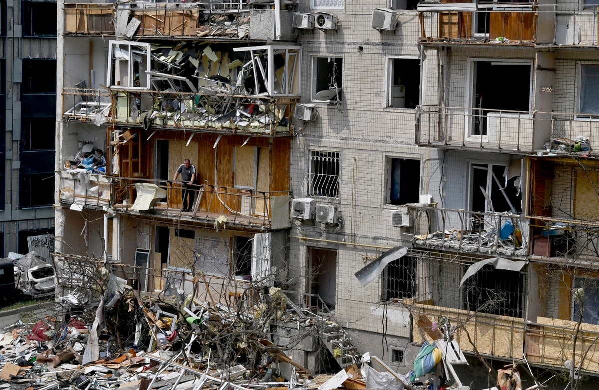 Un residente local se encuentra en el balcón de su departamento en un edificio residencial dañado por un ataque aéreo ruso contra la capital ucraniana, Kiev, el 3 de julio de 2026. Rusia lanzó su mayor ataque aéreo contra Kiev en la madrugada del 2 de julio, lo que causó la muerte de al menos 50 personas, según el alcalde de la ciudad. (Sergei Supinsky / AFP vía Getty Images)