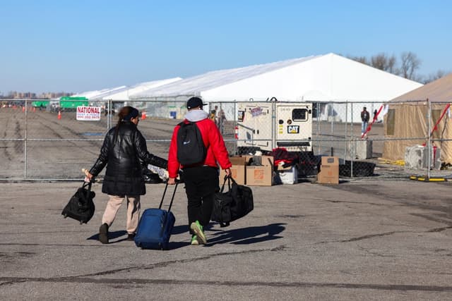 Inmigrantes se dirigen hacia los refugios en Floyd Bennett Field, en el distrito de Brooklyn de Nueva York, el 3 de febrero de 2024. (Charly Triballeau/AFP vía Getty Images)