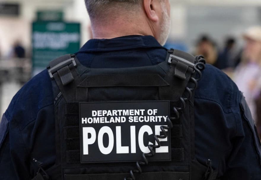 Un oficial del Departamento de Seguridad Nacional (DHS) da instrucciones a los pasajeros mientras esperan en fila en el Aeropuerto Intercontinental George Bush de Houston el 25 de marzo de 2026. (Antranik Tavitian/Reuters)