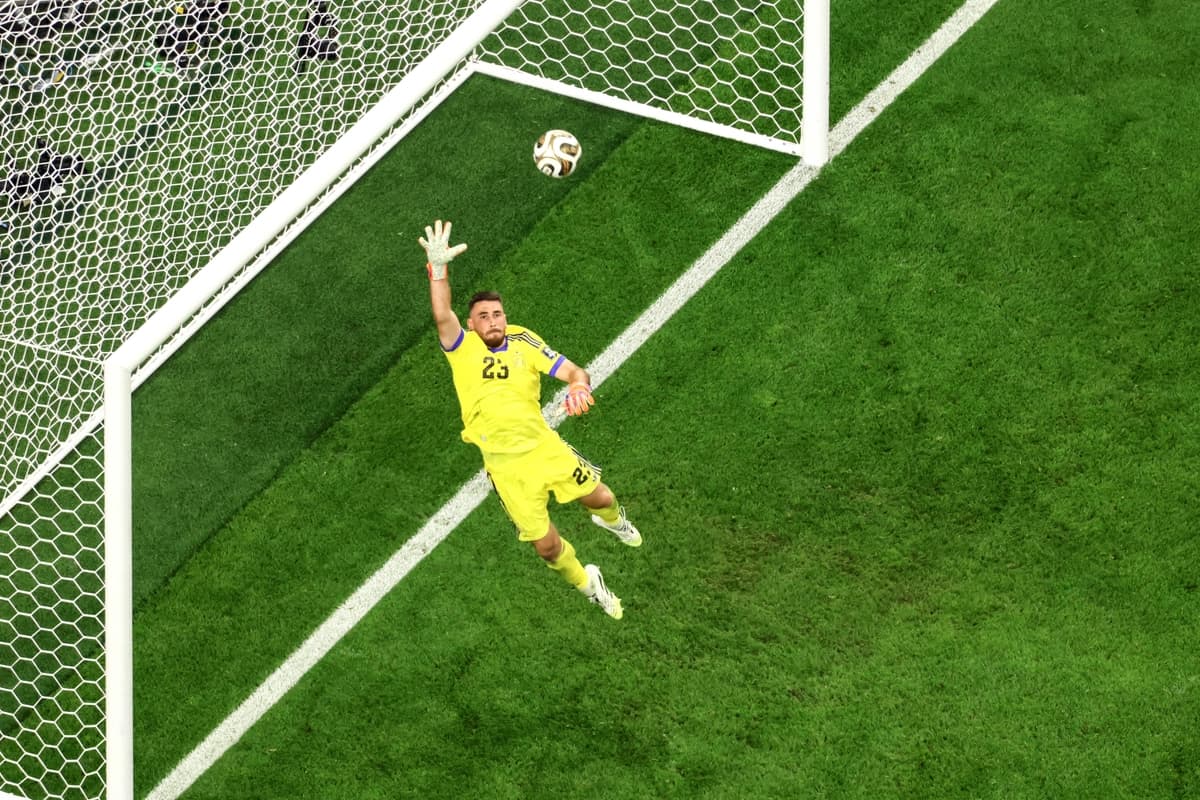 El portero número 23 de España, Unai Simón, salta para atajar un balón durante la semifinal del Mundial de fútbol de 2026 entre Francia y España en el Estadio de Dallas, en Arlington, el 14 de julio de 2026. (Odd Andersen/AFP vía Getty Images)