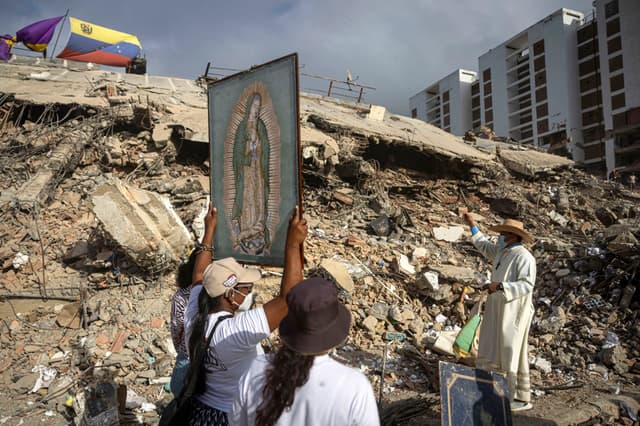 Fotografía de archivo que muestra personas junto al sacerdote Omar Pérez Gabino (d) durante un recorrido para acompañar con oraciones a familiares, voluntarios y rescatistas que continúan las labores de recuperación de cuerpos atrapados bajo los escombros tras los terremotos del pasado 24 de junio en Venezuela. (EFE/ Miguel Gutiérrez)