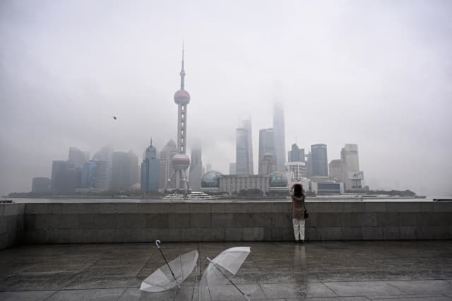 Una mujer toma una fotografía del distrito financiero de Lujiazui al otro lado del río Huangpu, en el paseo marítimo del Bund en Shanghái, China, el 5 de marzo de 2026. (Jade Gao/AFP vía Getty Images).
