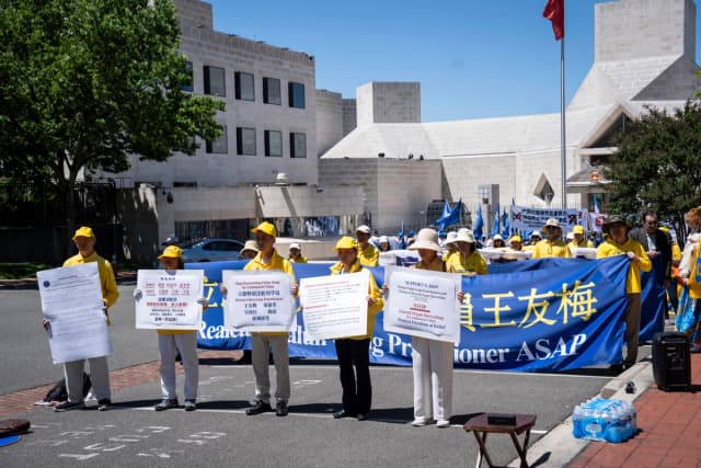 Practicantes de Falun Gong se concentran frente a la embajada china para apoyar a Alisa Zhou y Tong Shuzhen en Washington el 30 de mayo de 2026. La madre de Zhou, Wang Youmei, y la hermana de Tong, Tong Shuying, se encuentran detenidas desde abril en Wuhan, China, debido a su fe. (Madalina Kilroy/The Epoch Times)