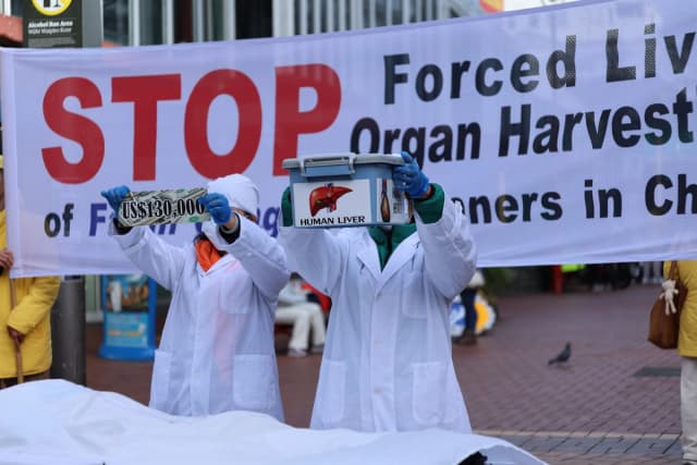 Activistas realizaron una dramática recreación vestidos con batas de laboratorio para crear conciencia y exigir el fin de la sustracción forzada de órganos en China durante una manifestación en Wellington, Nueva Zelanda, el 21 de julio de 2026. (Echo Wang/The Epoch Times)
