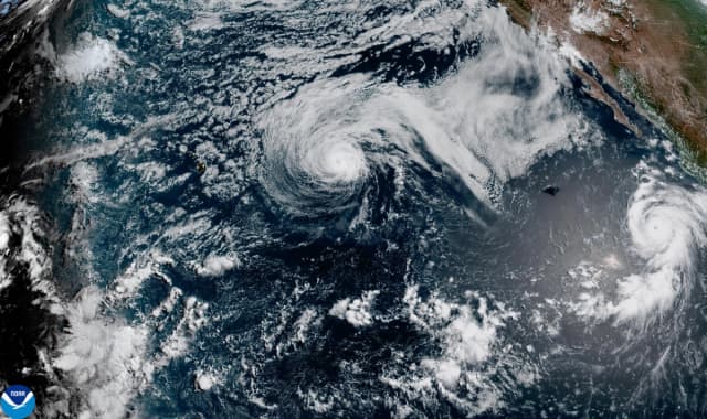Esta imagen de satélite difundida por la NOAA muestra al huracán Fausto, en el centro, y al huracán Genevieve frente a la costa suroeste de México, a la derecha, sobre el Océano Pacífico, el domingo 26 de julio de 2026. (NOAA vía AP)