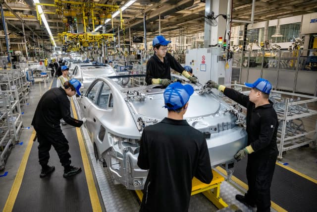 Trabajadores ensamblan el chasis de un auto en la línea de producción del fabricante de vehículos eléctricos Zeekr en su fábrica de Ningbo, China, el 29 de mayo de 2025. Canadá está permitiendo la entrada de un número cada vez mayor de vehículos eléctricos fabricados en China con un arancel del 6,1 por ciento, frente al 100 por ciento anterior. (Kevin Frayer/Getty Images)