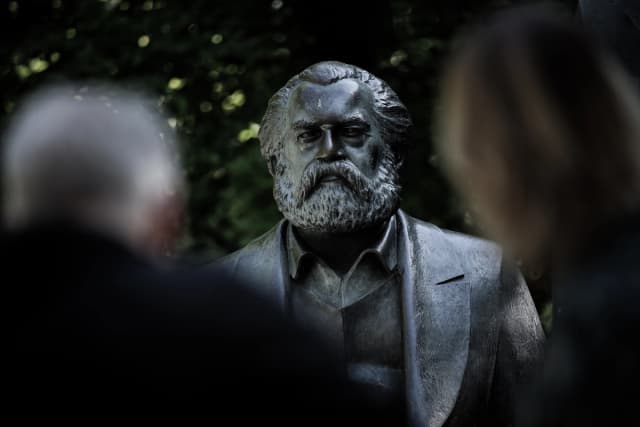 Visitantes observan una estatua de Karl Marx en un parque público de Berlín el 4 de mayo de 2018. (Sean Gallup/Getty Images).