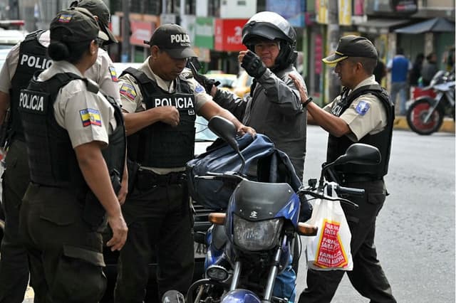 Agentes de policía registran a un motociclista durante una operación policial en el barrio de Martha Bucaram, al sur de Quito, el 4 de agosto de 2026. El gobierno ecuatoriano desplegó el 3 de agosto de 2026 a 4000 agentes de policía y militares en Quito para reforzar la seguridad en la capital, tras el hallazgo de un cadáver decapitado y las denuncias de personas desaparecidas en las últimas semanas. (Rodrigo BUENDIA / AFP vía Getty Images)