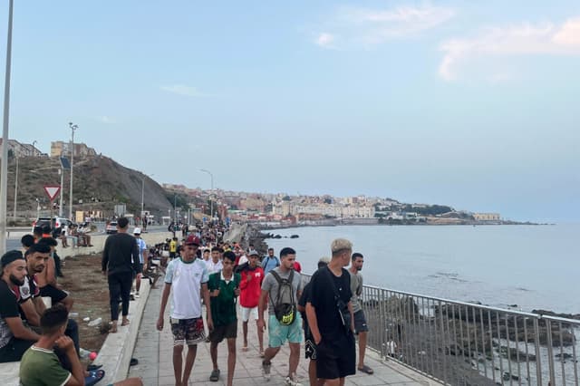 Migrantes marroquíes caminan por la Avenida Martínez Catena en Ceuta hacia la zona fronteriza el 31 de julio de 2026. (Etienne Fauchaire para The Epoch Times).
