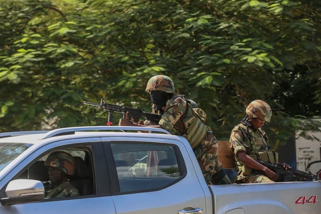 Soldados patrullan en medio del sonido de disparos que se escuchan a lo lejos en Puerto Príncipe, Haití, el 17 de octubre de 2024. (Odelyn Joseph/AP Photo)