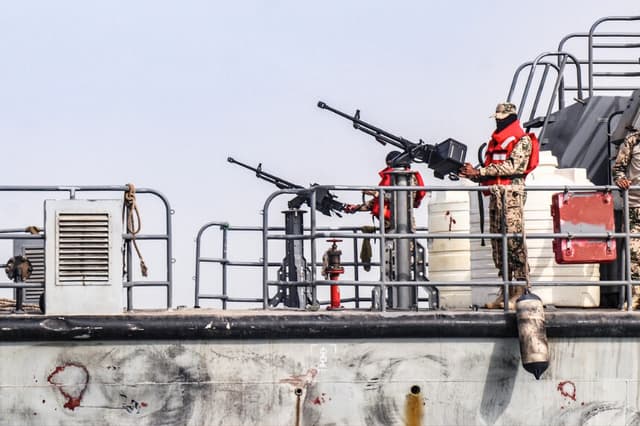 Marineros de la marina del gobierno internacionalmente reconocido en Adén en Yemen se encuentran en posiciones de ametralladora a bordo de un buque que patrulla una ruta marítima frente a la isla Hanish en el Mar Rojo el 27 de julio de 2026. (Khaled Ziad / AFP vía Getty Images).