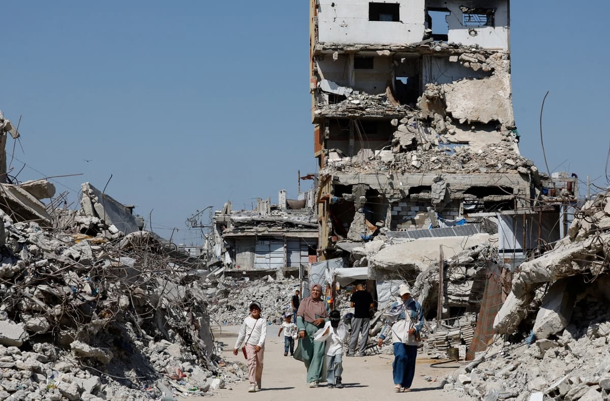 Palestinos pasan junto a los escombros de edificios residenciales destruidos durante la guerra, en el campamento de refugiados de Jabalia, en el norte de la Franja de Gaza, el 5 de agosto de 2026. (Mahmoud Issa/Reuters)