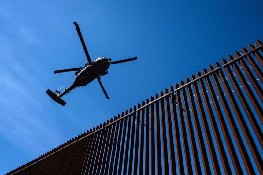 Un helicóptero de la Patrulla Fronteriza de EE. UU. sobrevuela la valla fronteriza entre EE. UU. y México mientras el presidente de EE. UU., Donald Trump, visita Calexico, California, visto desde Mexicali, estado de Baja California, México, el 5 de abril de 2019. (GUILLERMO ARIAS/AFP vía Getty Images)