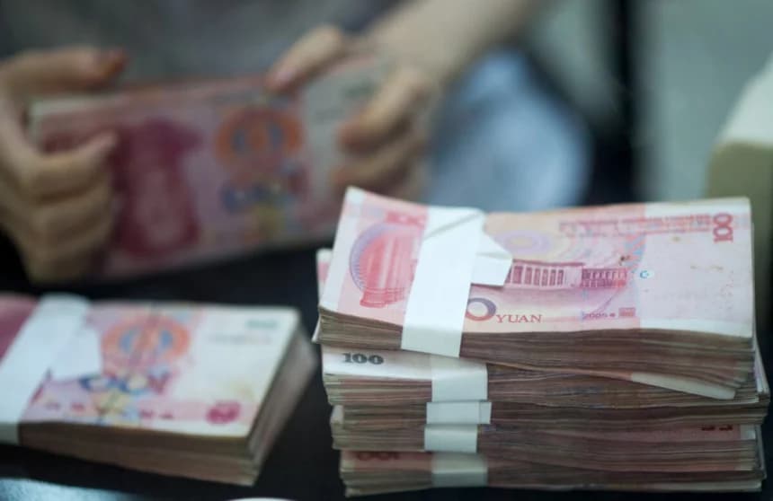 Una trabajadora en una sucursal bancaria cuenta dinero mientras atiende a un cliente en la zona piloto de libre comercio de China (Shanghái) durante un recorrido para medios el 24 de septiembre de 2014. (Johannes Eisele/AFP vía Getty Images)