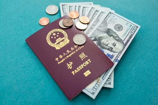 Pasaporte chino y moneda extranjera para viajes internacionales en una foto de archivo. (Getty Images).