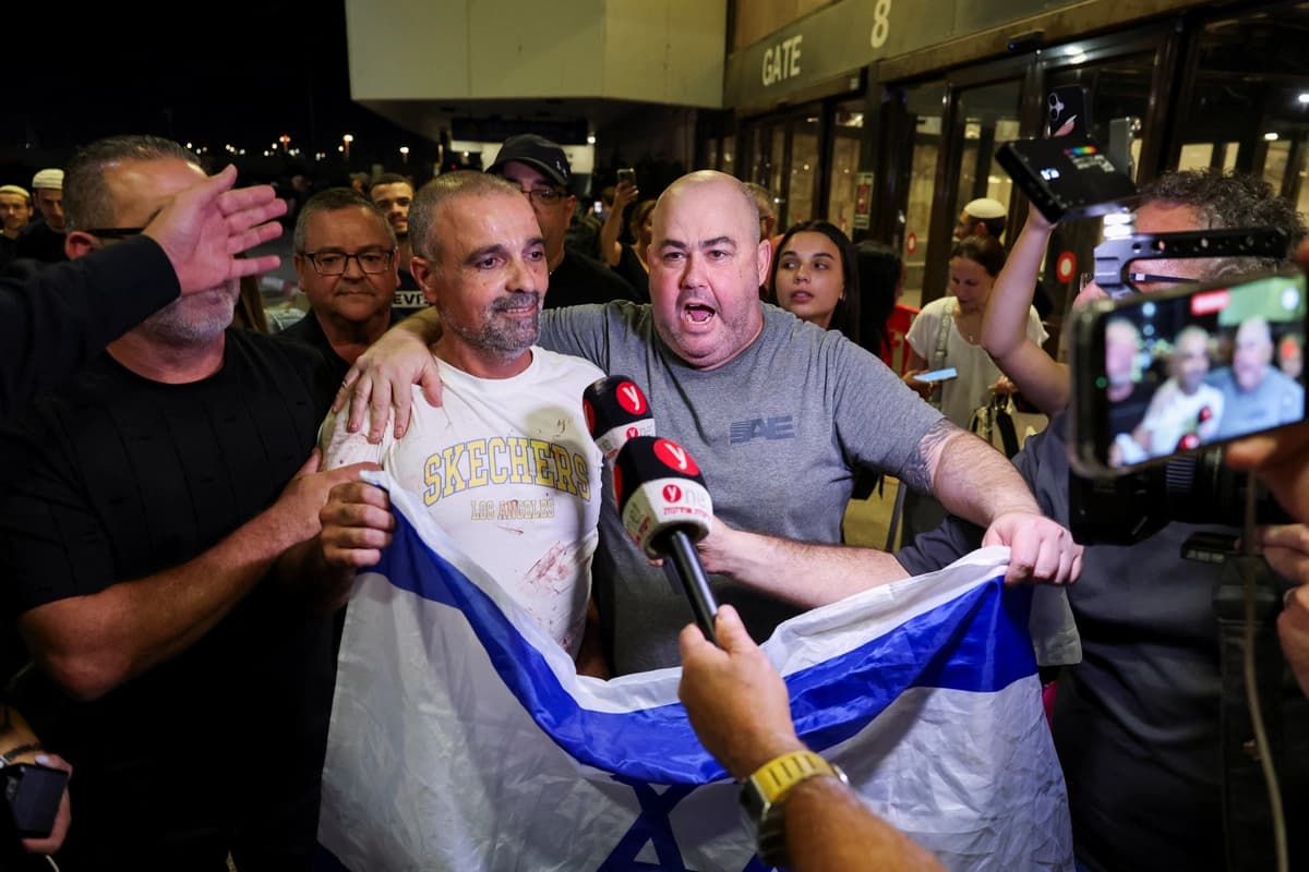 Yaniv Hayun (segundo por la izquierda), uno de los hombres que ayudó a neutralizar a un atacante en un avión de FlyDubai con destino a Israel, sostiene una bandera israelí tras llegar al Aeropuerto Internacional Ben Gurión, cerca de Tel Aviv, Israel, el 30 de septiembre de 2026. (Ammar Awad/Reuters)