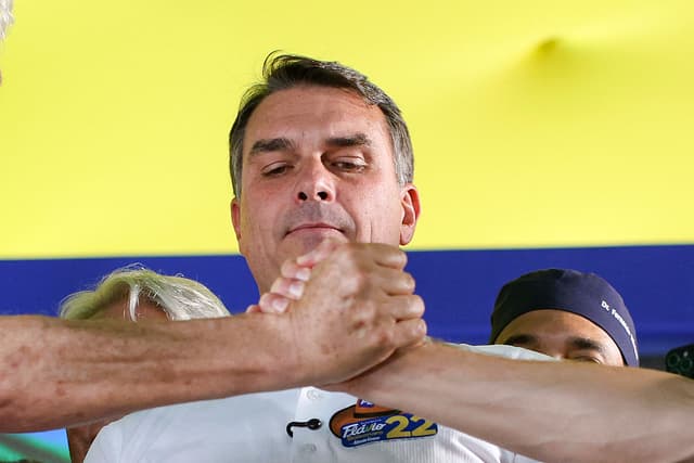 El senador brasileño y candidato presidencial del Partido Liberal (PL), Flavio Bolsonaro, observa cómo sus seguidores se dan la mano durante un mitin en Goiânia, estado de Goiás, Brasil, el 6 de octubre de 2026. (Foto de Sergio Lima / AFP vía Getty Images)