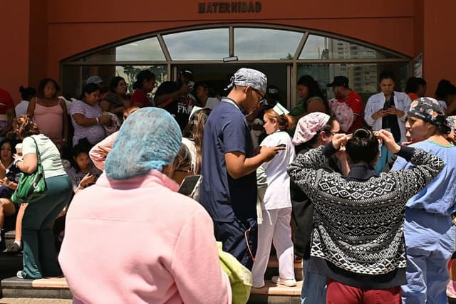 Varias personas se encuentran frente a la unidad de maternidad del hospital de Santo Tomás, tras el fuerte terremoto de magnitud 8 que sacudió el país, en la Ciudad de Panamá el 9 de octubre de 2026. (MARTIN BERNETTI / AFP vía Getty Images)