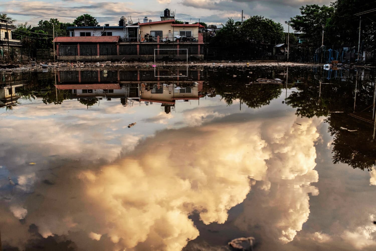 En la imagen se aprecia el reflejo del cielo en un charco de un campo de fútbol cubierto de agua y barro a causa de las fuertes lluvias, en el barrio de Las Granjas de Poza Rica, en el estado de Veracruz (México), el 14 de octubre de 2025. (Héctor Quintanár / AFP vía Getty Images)