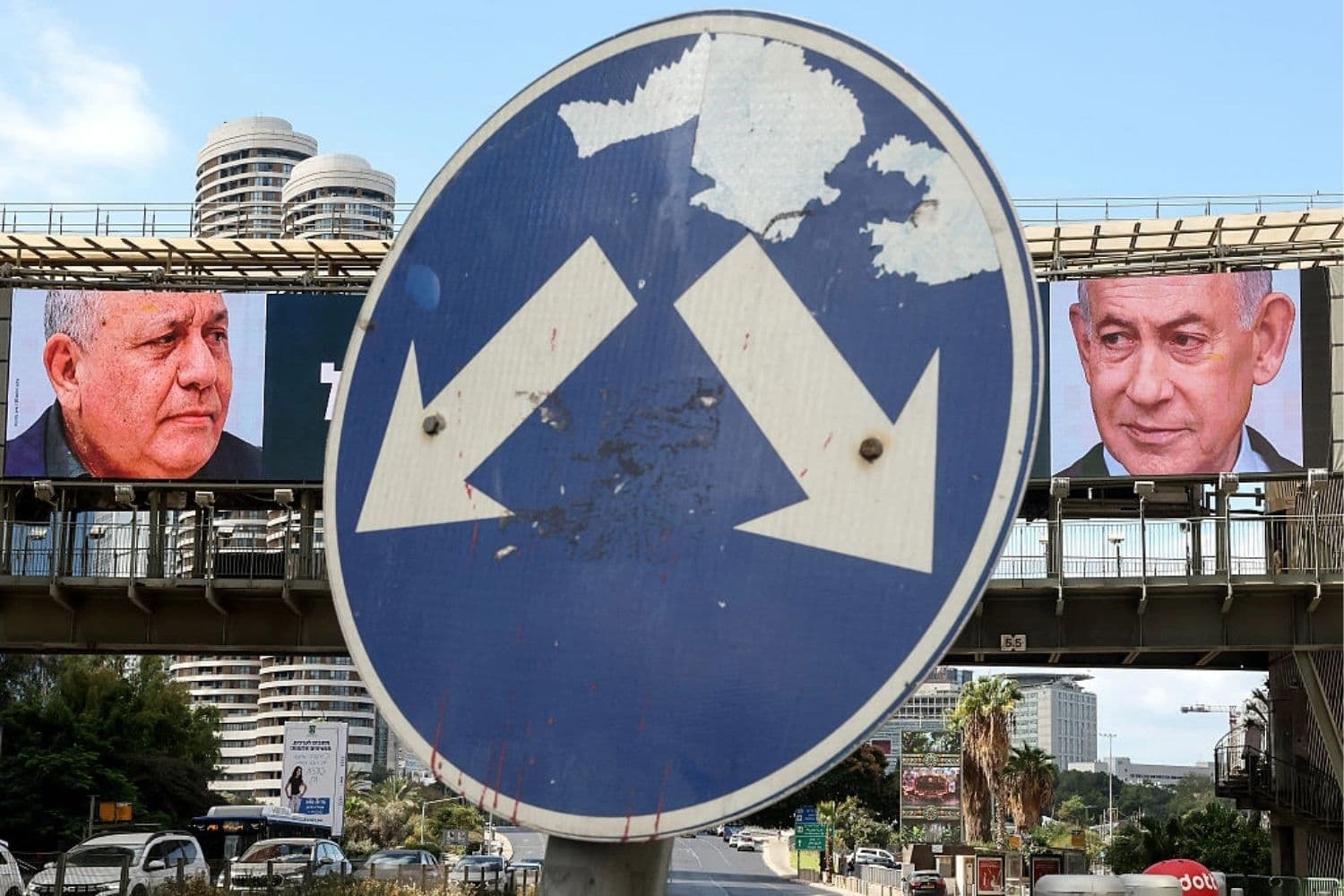 Una señal de tráfico se encuentra frente a una gran valla publicitaria en la que aparecen el primer ministro israelí, Benjamin Netanyahu (derecha), del Partido Likud, y el exjefe militar y líder del Partido Yashar, Gadi Eisenkot (izquierda), en Ramat Gan, Tel Aviv, el 20 de octubre de 2026. (Jack Guez/AFP vía Getty Images)